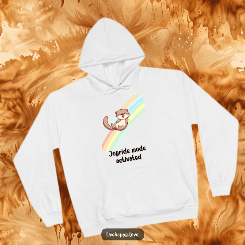 Funny hoodie showing an energetic otter sliding down a bright rainbow, with its tail leaving a trail of sparkling joy behind.